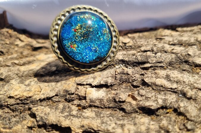 Bijutricotaje.ro | Albastru cu auriu și negru un inel din bronz, cu pulberi sclipitoare Bijutricotaje.ro|Albastru cu auriu și negru un inel din bronz, cu pulberi sclipitoare